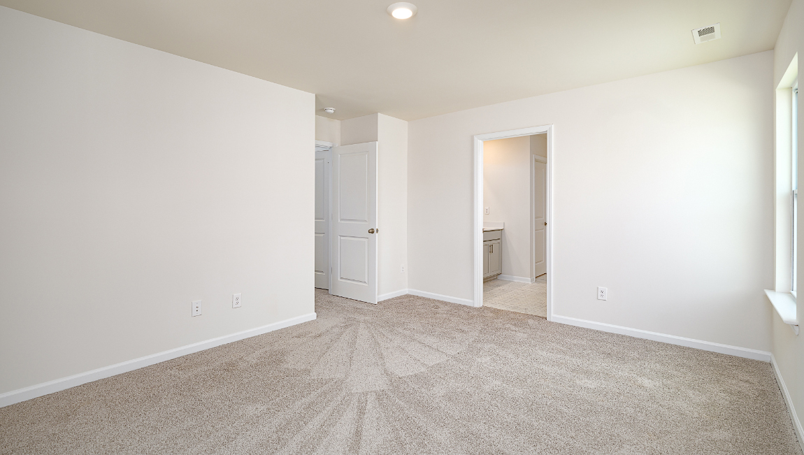 Primary bedroom, carpeted with large windows