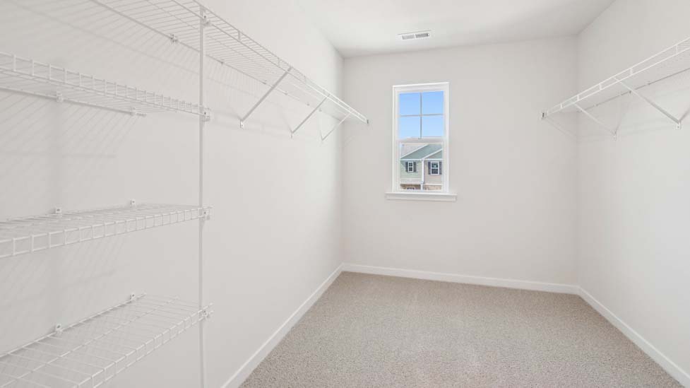 Primary bedroom carpeted walkin closet