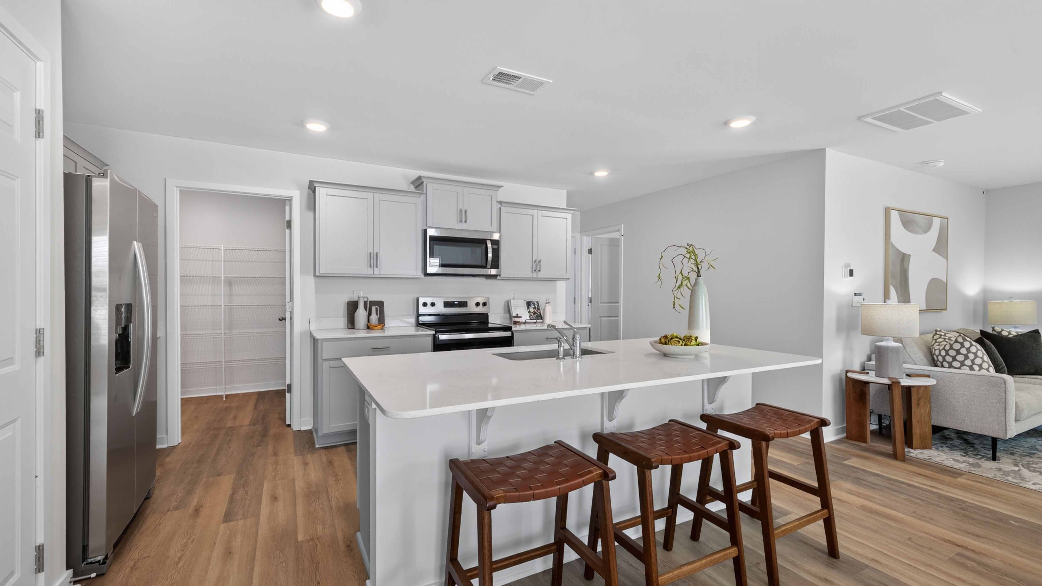 Kitchen and island with white cabinets, subway tile backsplash, and stainless steel appliances