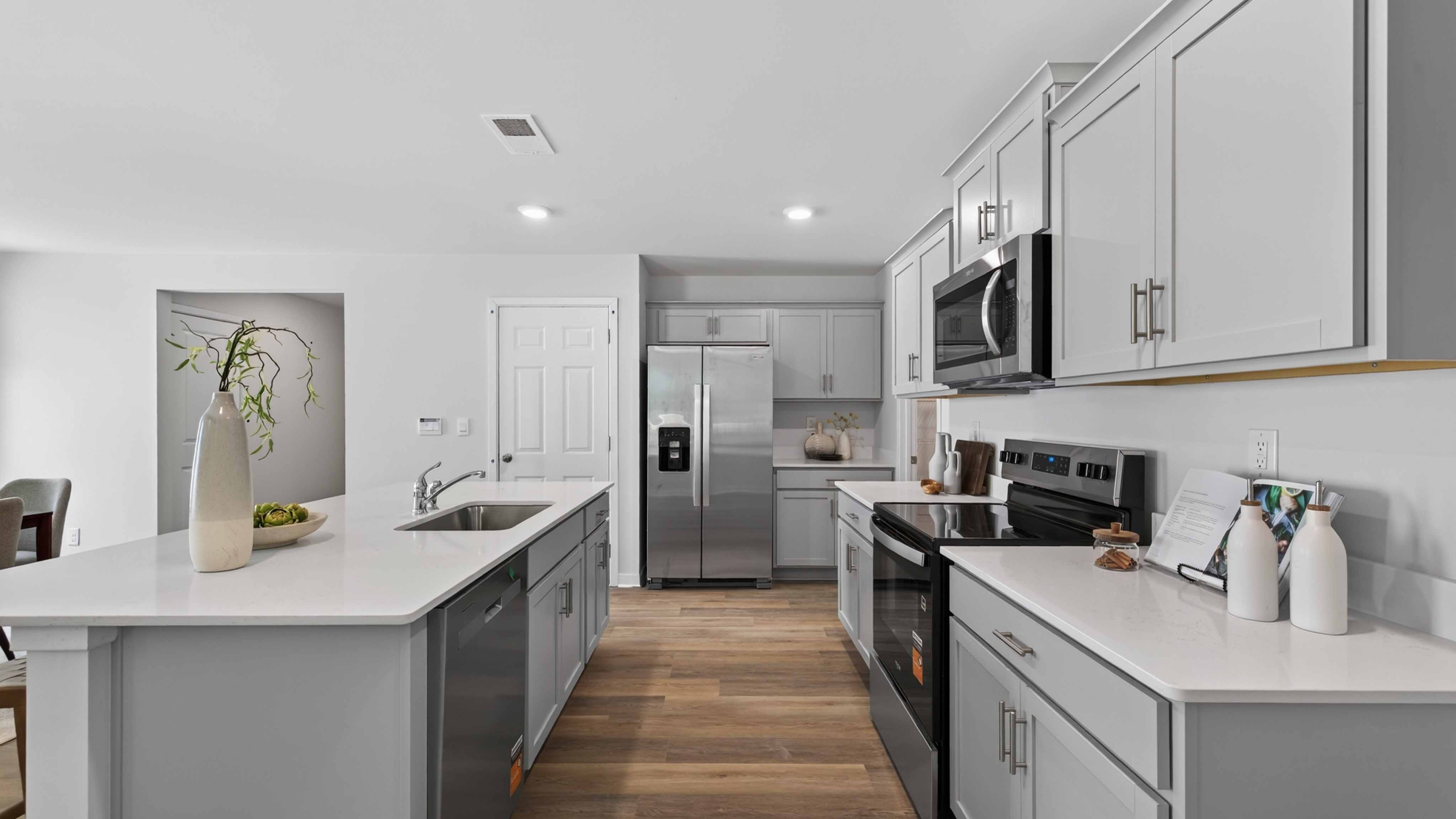 Kitchen and island with white cabinets, subway tile backsplash, and stainless steel appliances