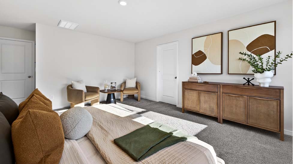 Primary carpeted bedroom with large window, view of bathroom door