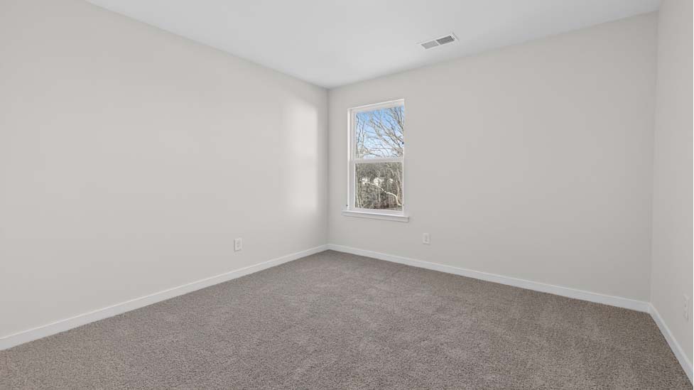Carpeted bedroom  with small window