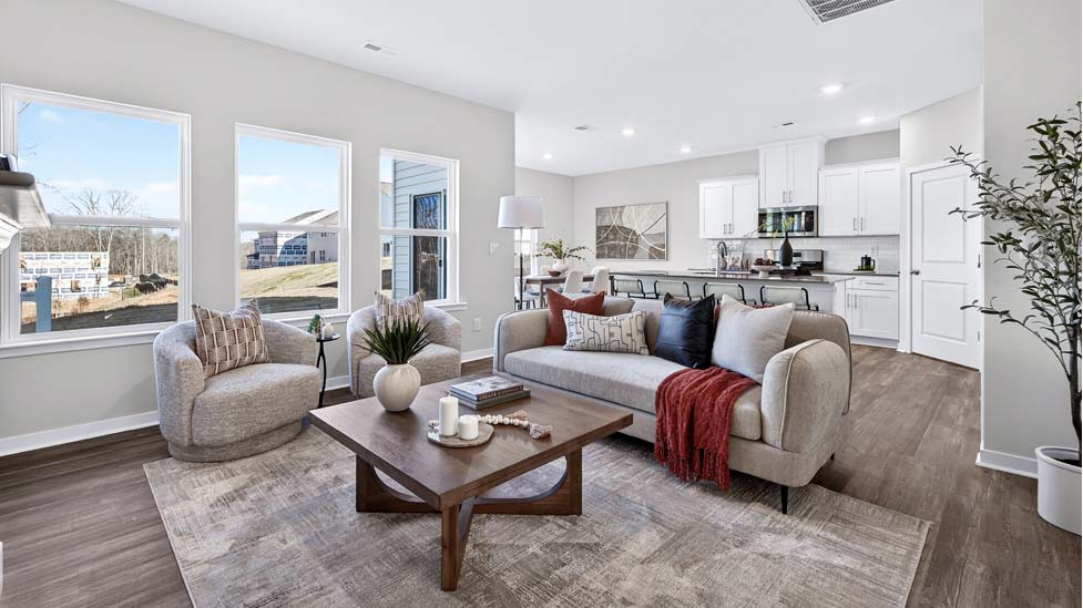 Living room space with wood floors, three large windows