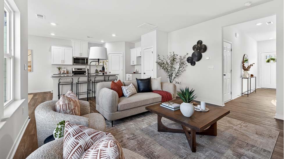 Living room space with wood floors, three large windows
