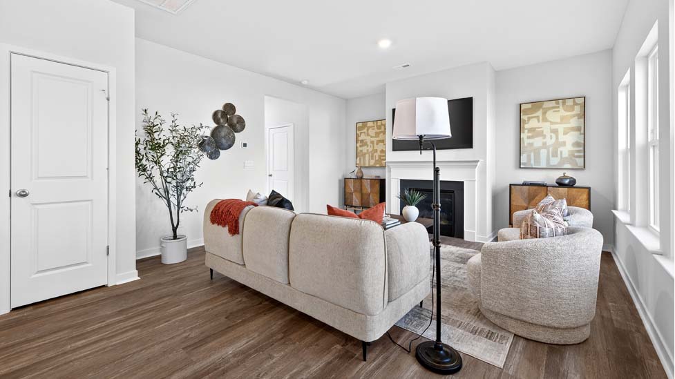 Living room space with wood floors, three large windows
