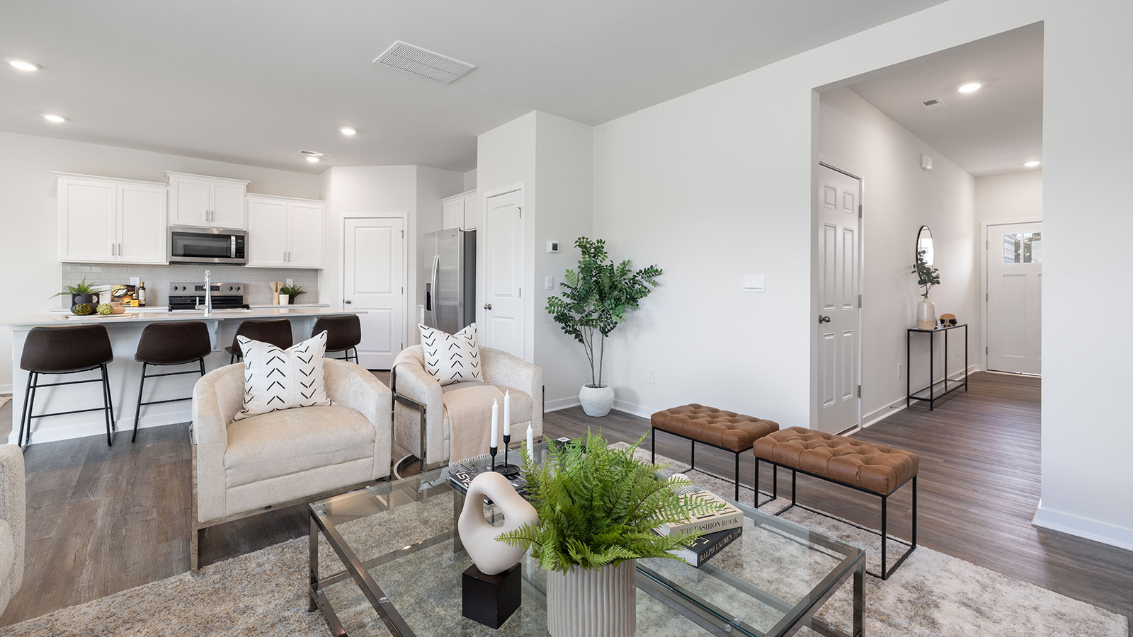 Living room space with wood floors, three large windows