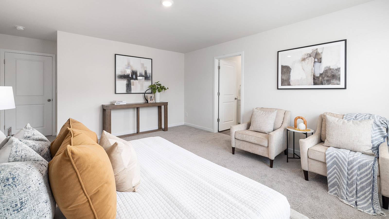Carpeted bedroom with large window, view of bathroom door