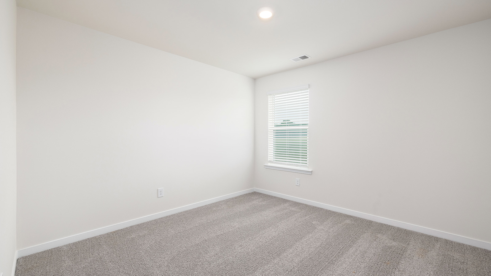 Carpeted bedroom with large window, view of bathroom door