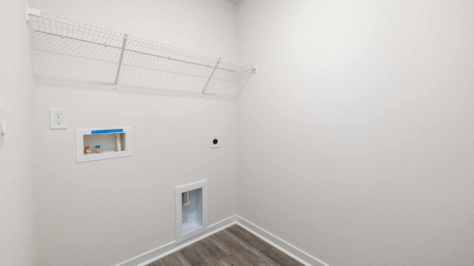 Laundry room with built in racks for hanging above machine space