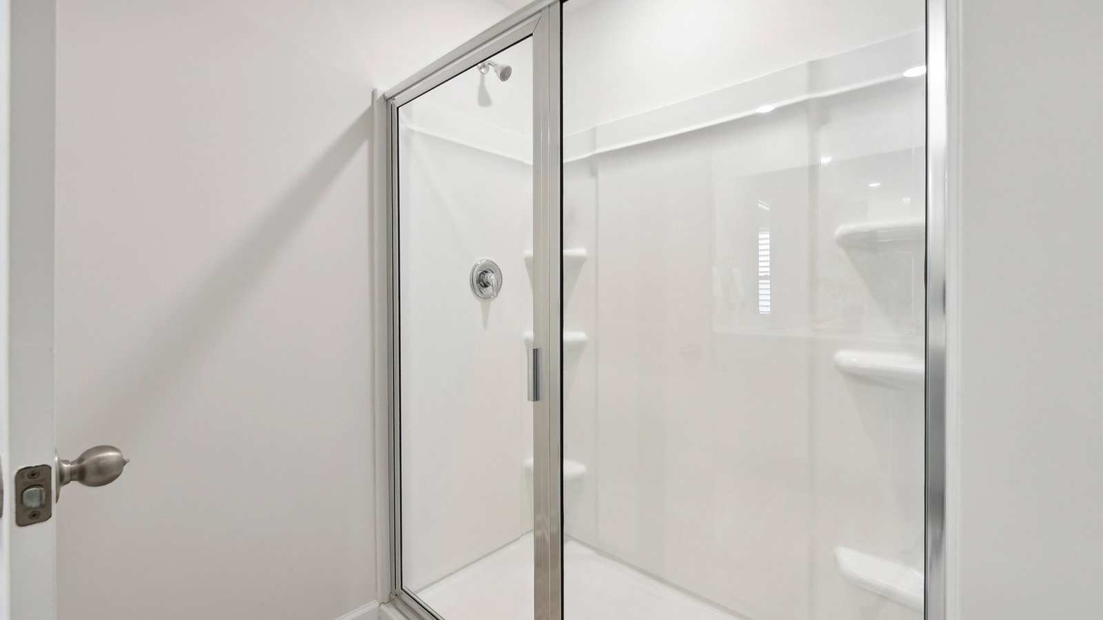 Primary bathroom with double sinks, white cabinets and counters