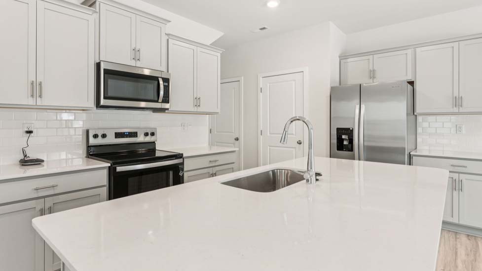 Kitchen beside living room with stainless steel appliances