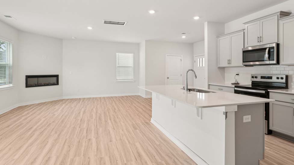 Kitchen beside living room with stainless steel appliances