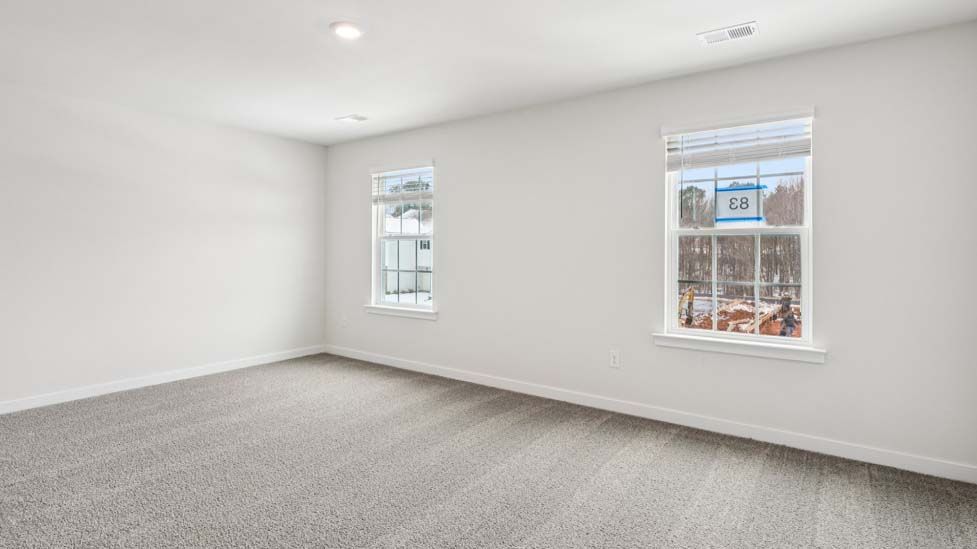 Primary bedroom with carpet and large windows