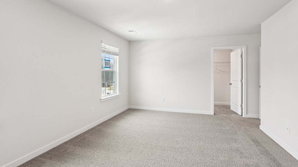 Primary bedroom with carpet and large windows