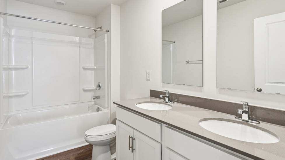 Bathroom with bathtub shower combo and double sink vanity