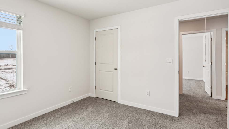 Carpeted bedroom with small window