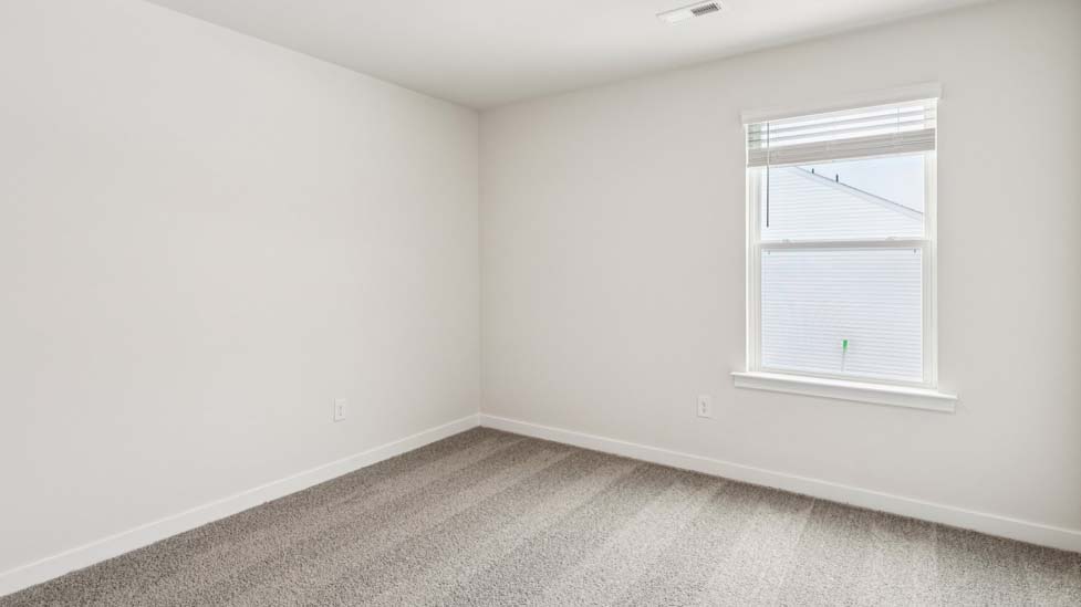 Carpeted bedroom with small window