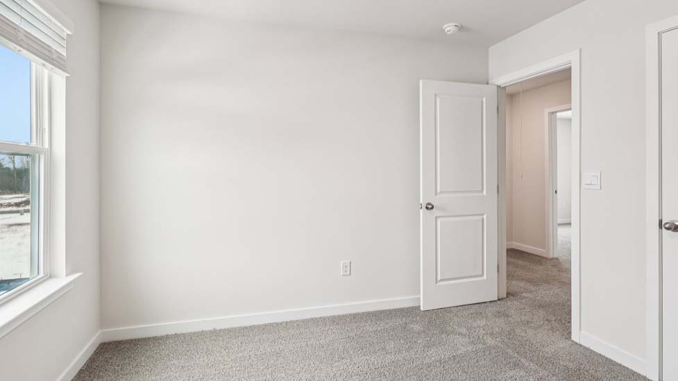 Carpeted bedroom with small window