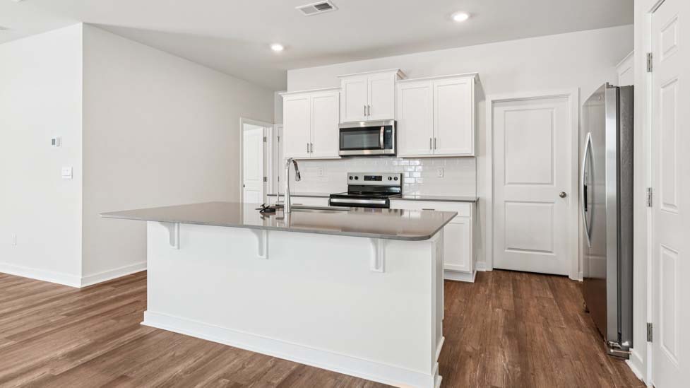 Kitchen and island with stainless steel appliances