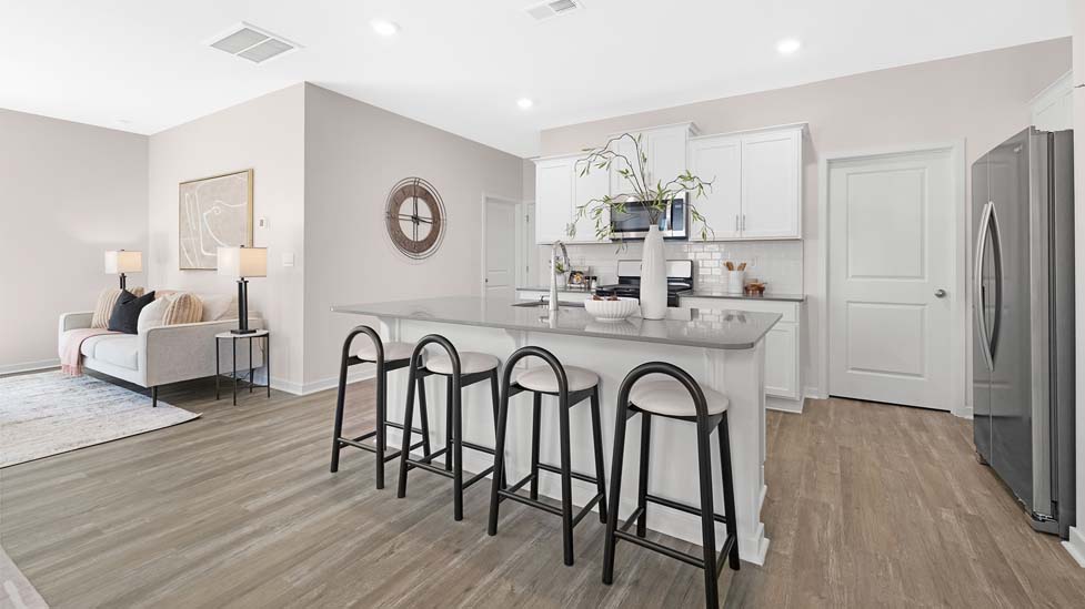 Kitchen and island with white cabinets, subway tile backsplash, and stainless steel appliances