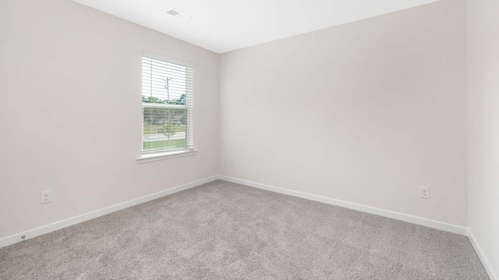 Carpeted bedroom with large window