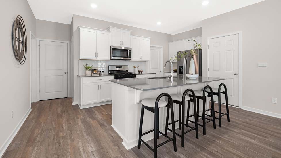 Kitchen and island with white cabinets, subway tile backsplash, and stainless steel appliances