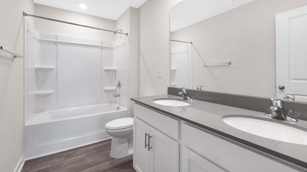 Bathroom with standing shower, white counter and cabinets