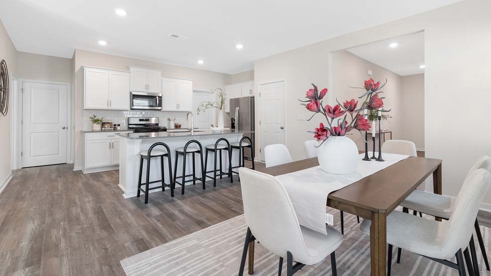 Kitchen and island with white cabinets, subway tile backsplash, and stainless steel appliances