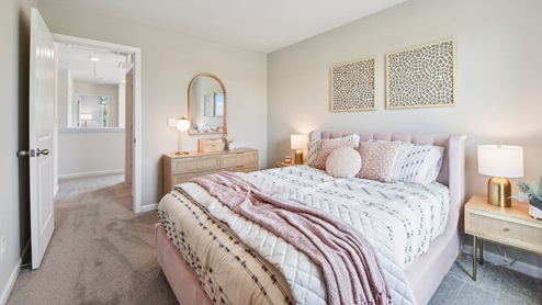 Carpeted bedroom with small window. New Home in Charlotte, North Carolina