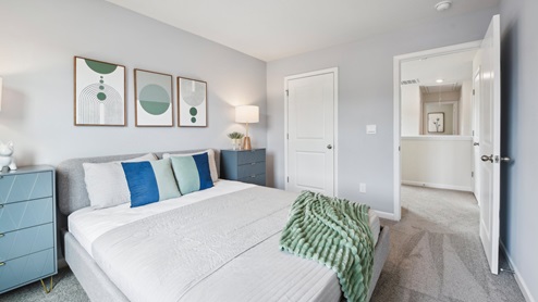 Carpeted bedroom with small window. New Home in Charlotte, North Carolina