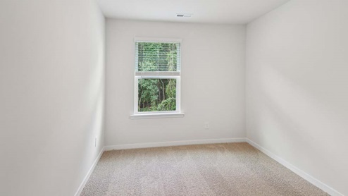 Carpeted bedroom with large window