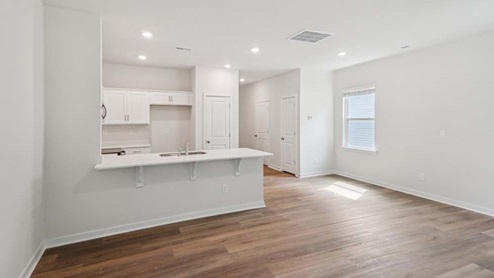 Kitchen area with white cabinets and stainless steel appliances