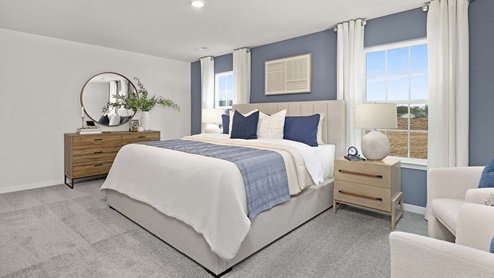 Primary bedroom with carpet and large windows