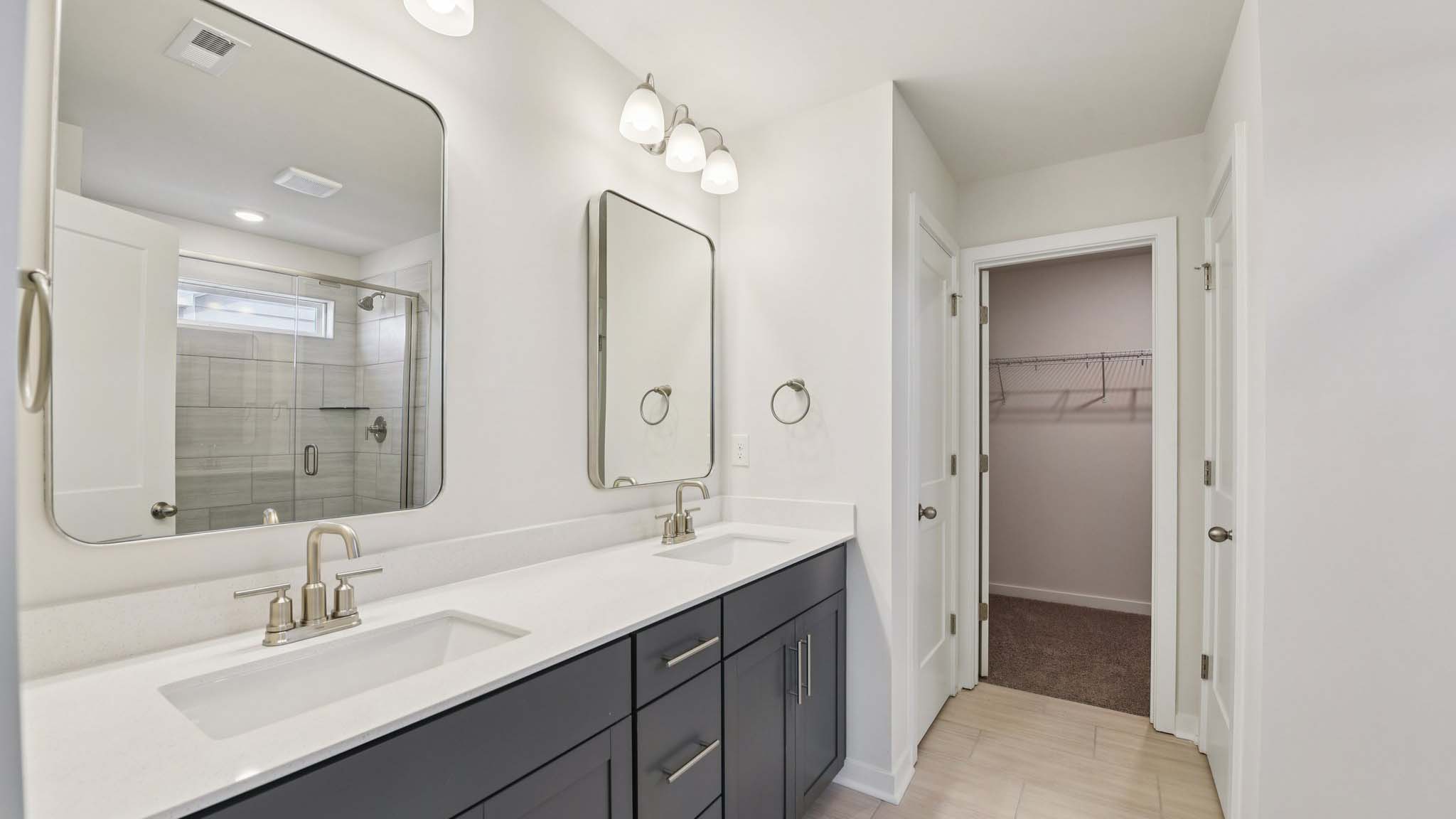 Primary bathroom with double sinks and standing glass shower