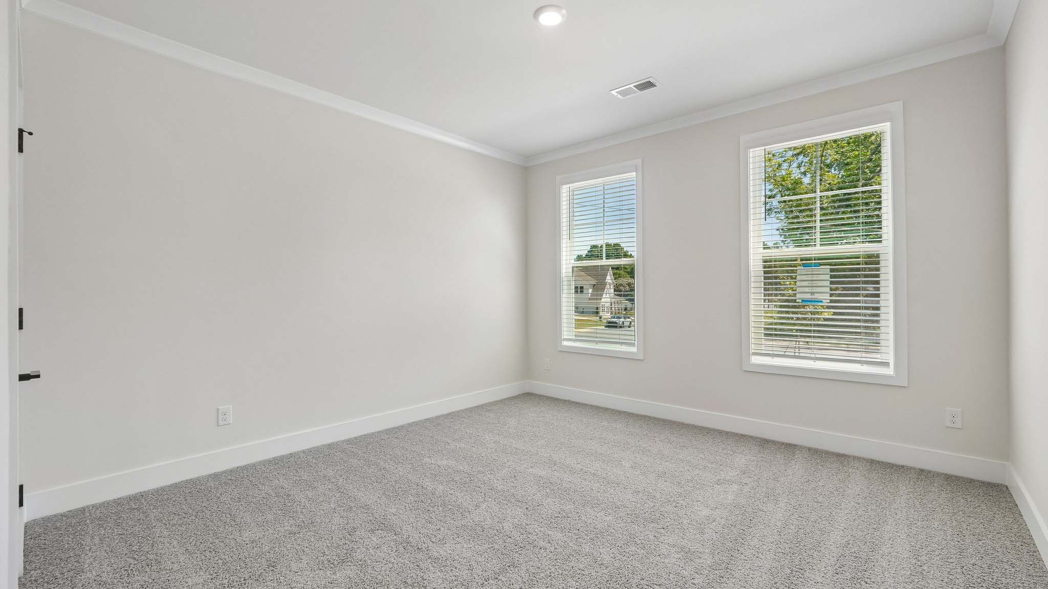 Carpeted bedroom with windows