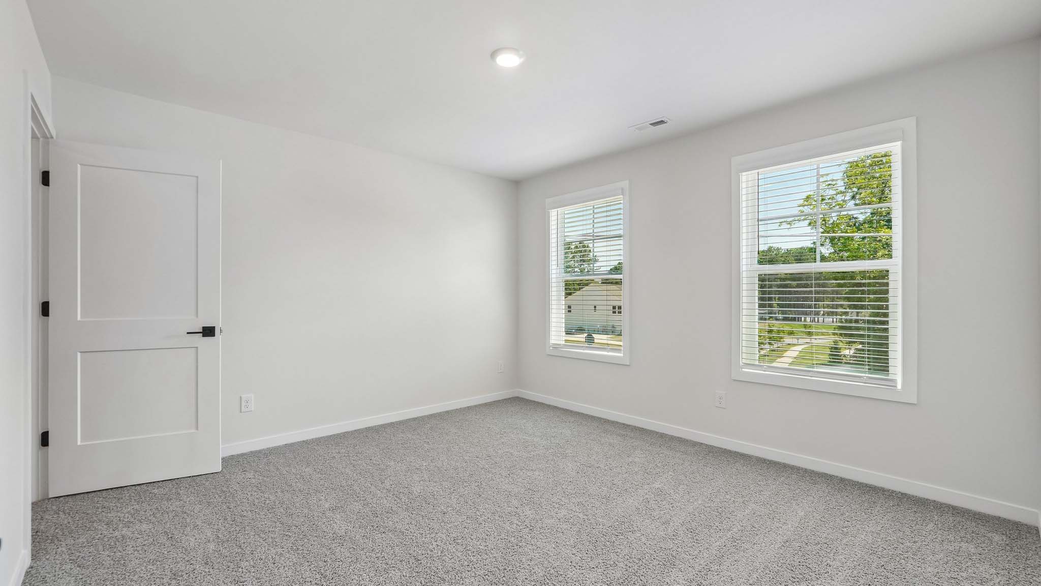 Carpeted bedroom with windows
