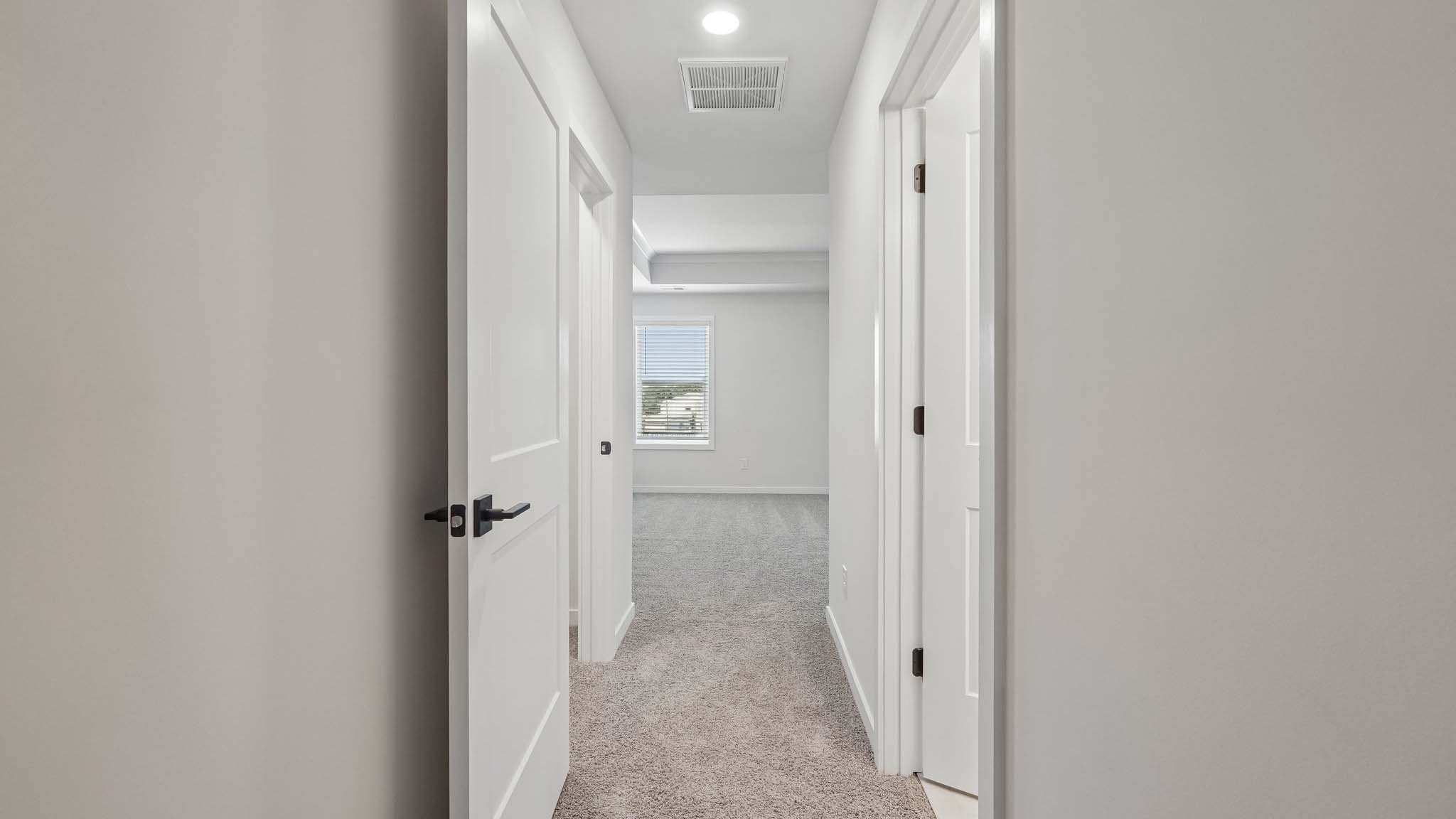 Primary carpeted bedroom with windows