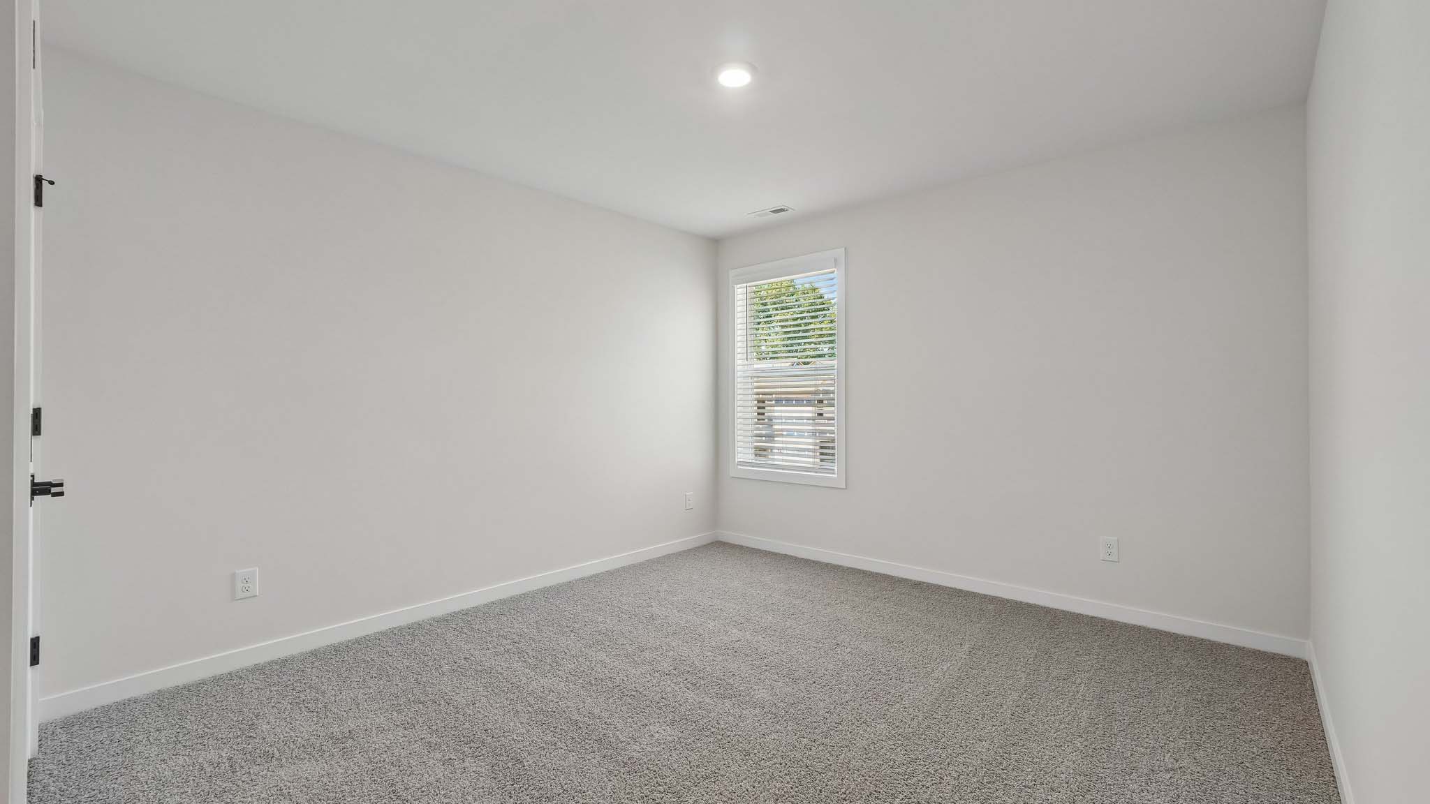 Carpeted bedroom with windows