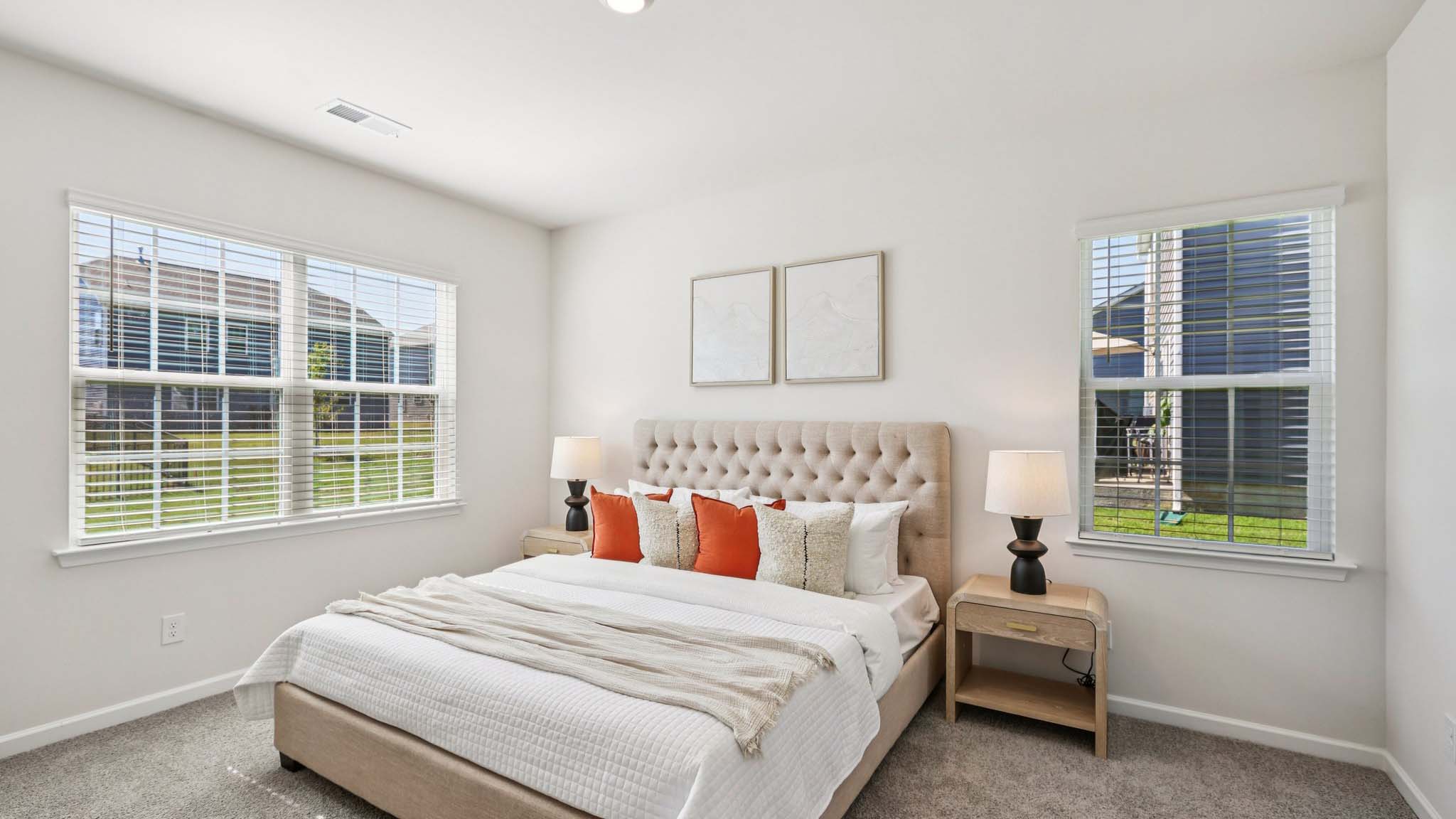 Primary carpeted bedroom with windows