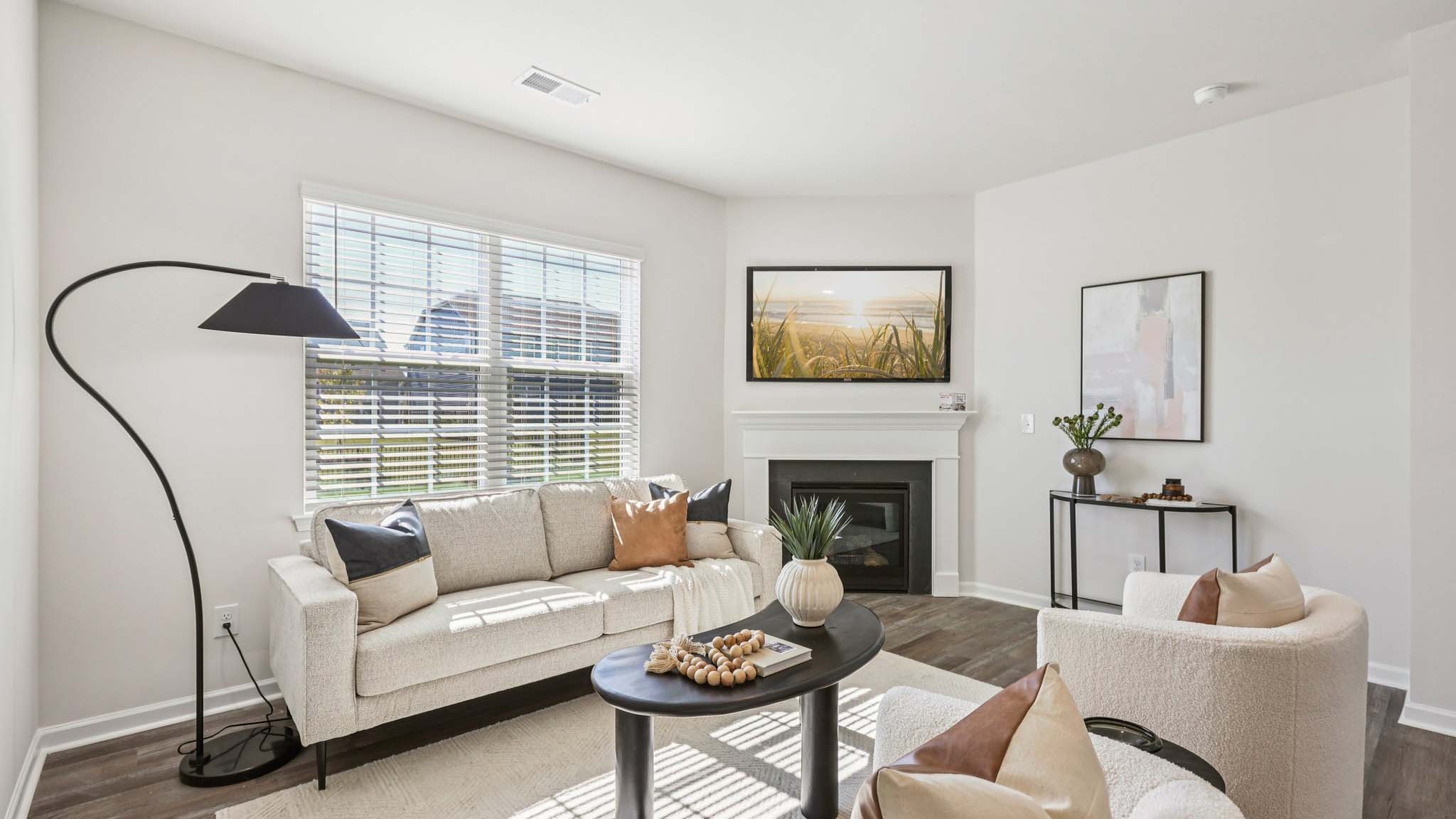 Open living room with wood floors, large window, and fireplace