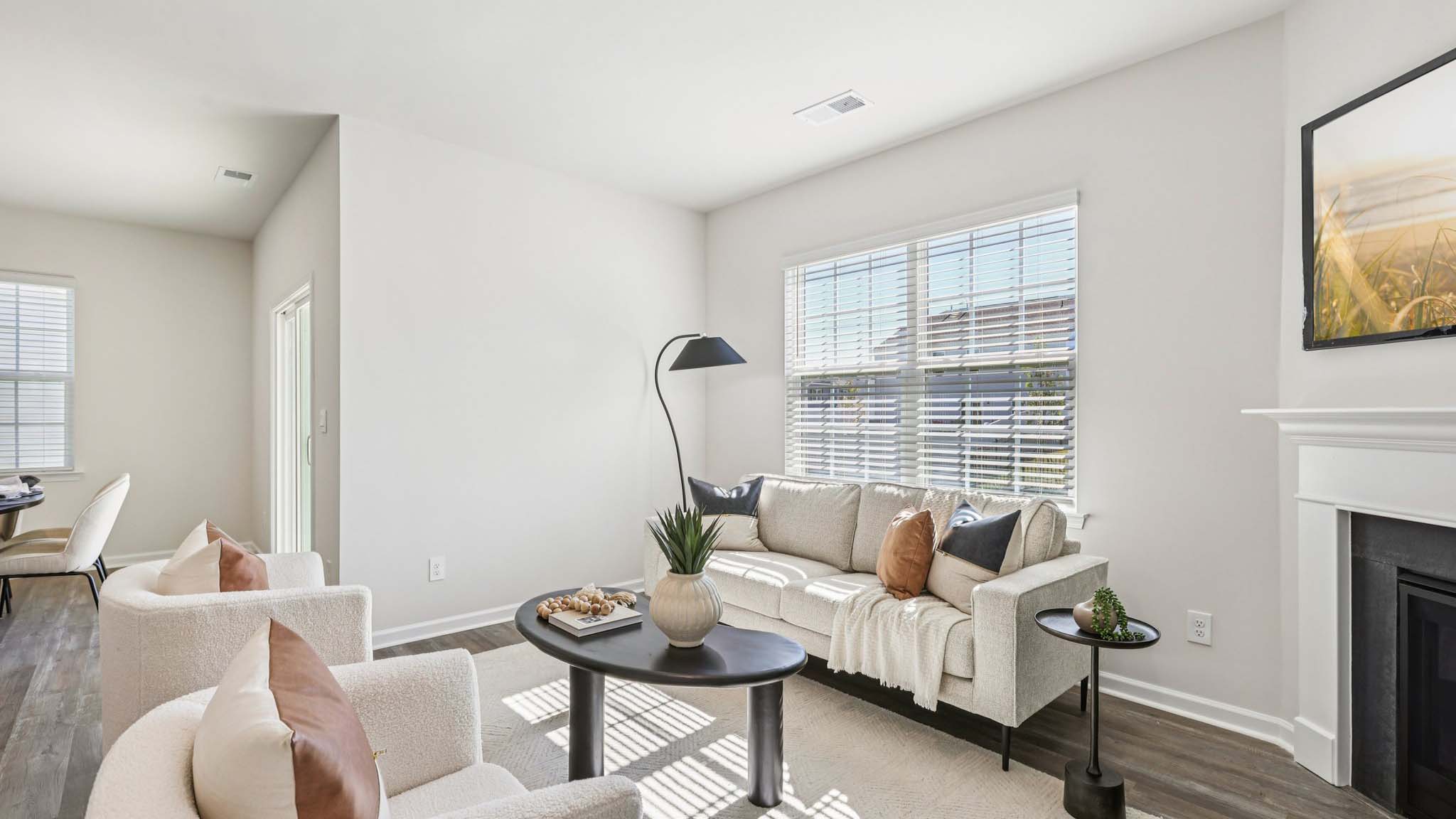 Open living room with wood floors, large window, and fireplace