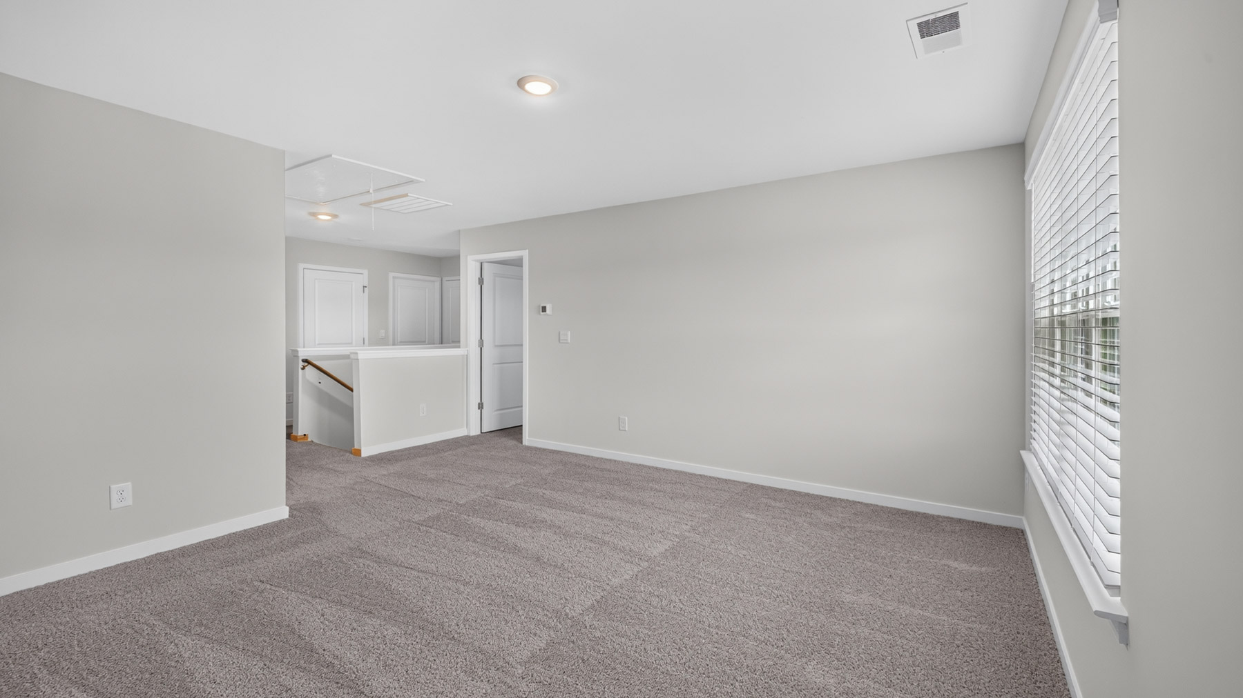 Upstairs carpeted loft with windows