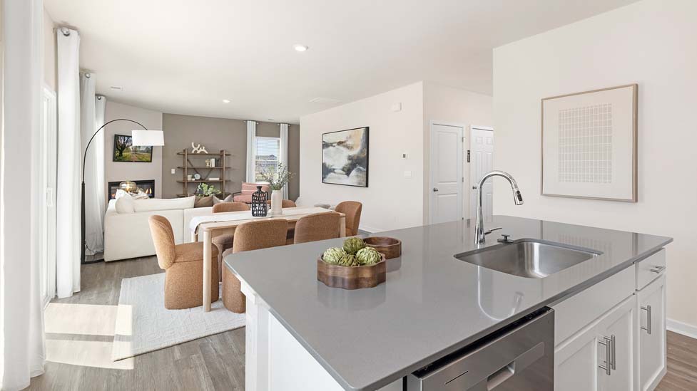 Kitchen and island with white cabinets, quarts countertops, wood floors, and stainless steel appliances