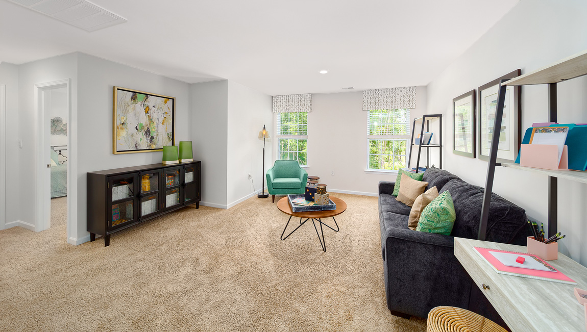 Spacious carpeted upstairs loft space with two large windows