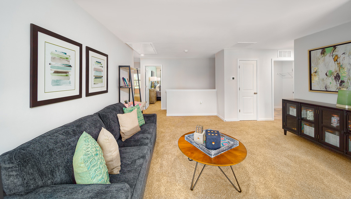 Spacious carpeted upstairs loft space with two large windows