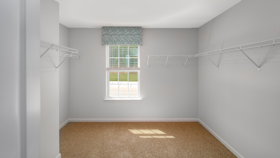 Primary carpeted walk in closet