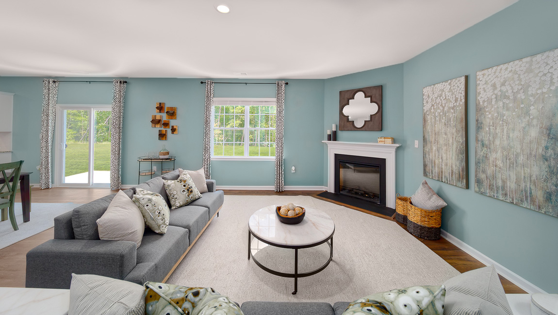 Open family room with fireplace, windows, and view of dining and kitchen