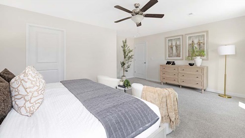 Primary bedroom with carpet, ceiling fan, and large windows