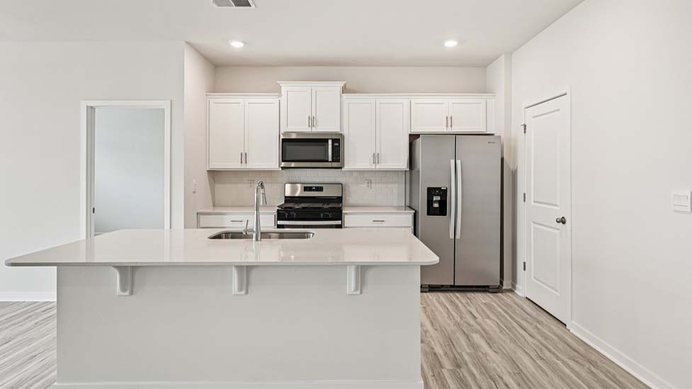 Kitchen and island with stainless steel appliances