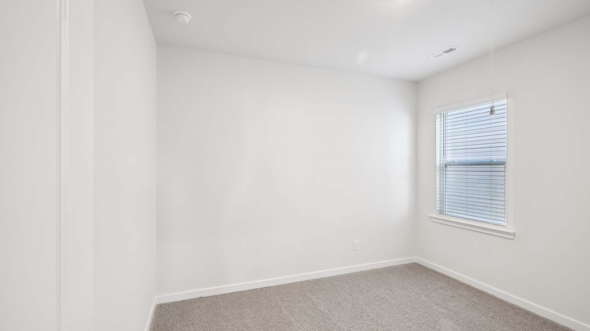 Carpeted bedroom with windows